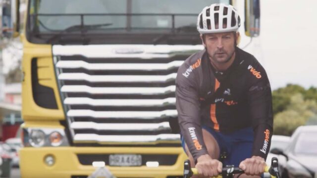 person riding a bike in front of a truck