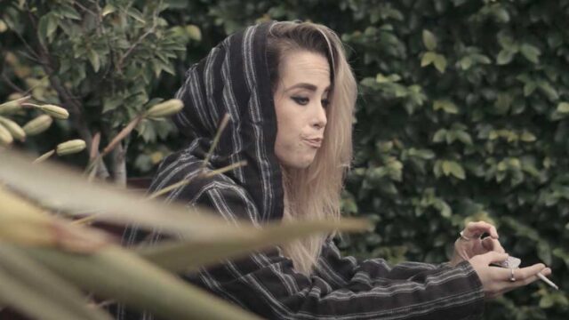 person sitting looking sad, smoking.